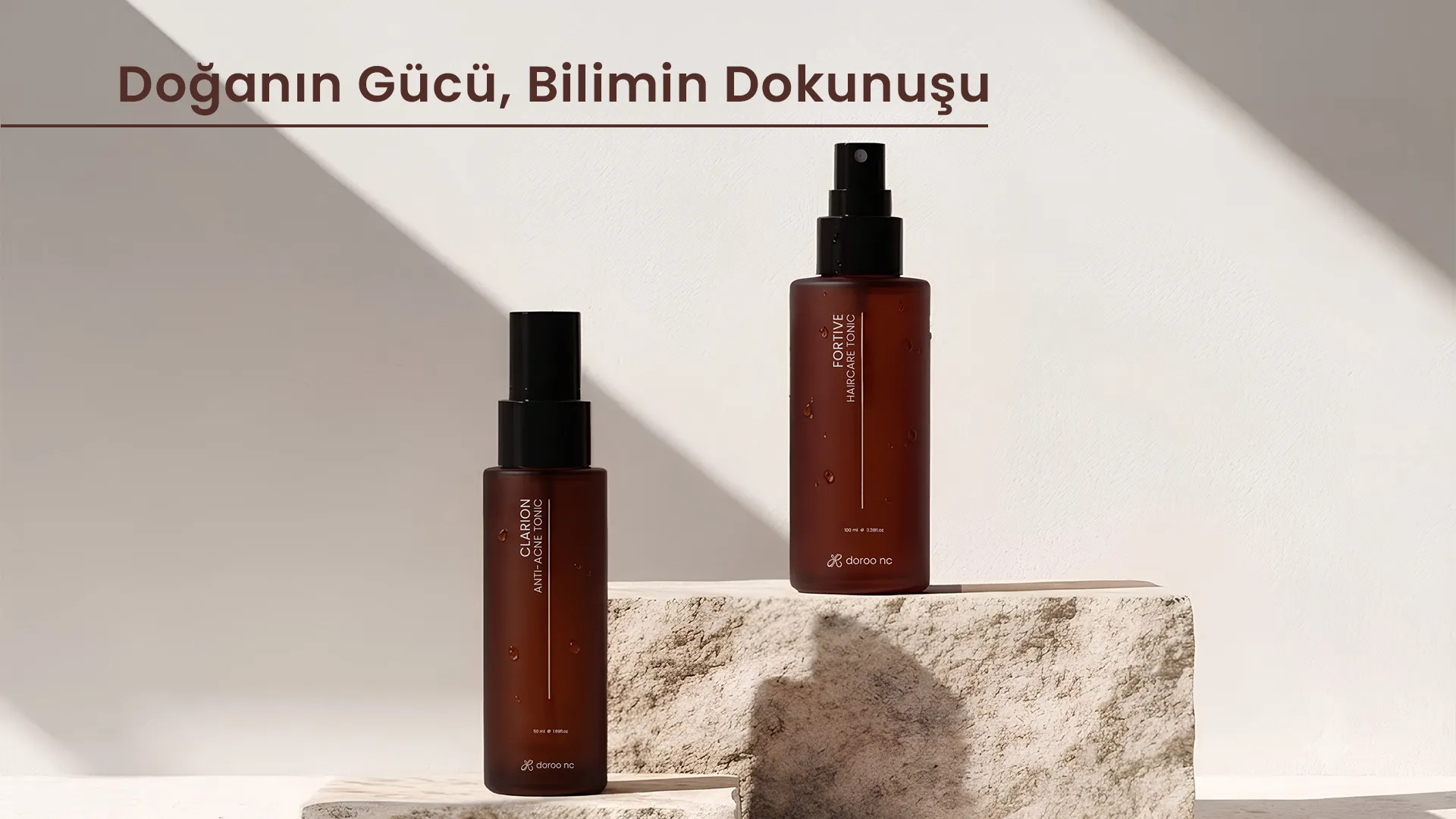 Güneş ışığında taş bir kaide üzerinde duran Clarion anti-akne toniği ve Fortive saç bakım toniği; görselde “Doğanın Gücü, Bilimin Dokunuşu” yazısı