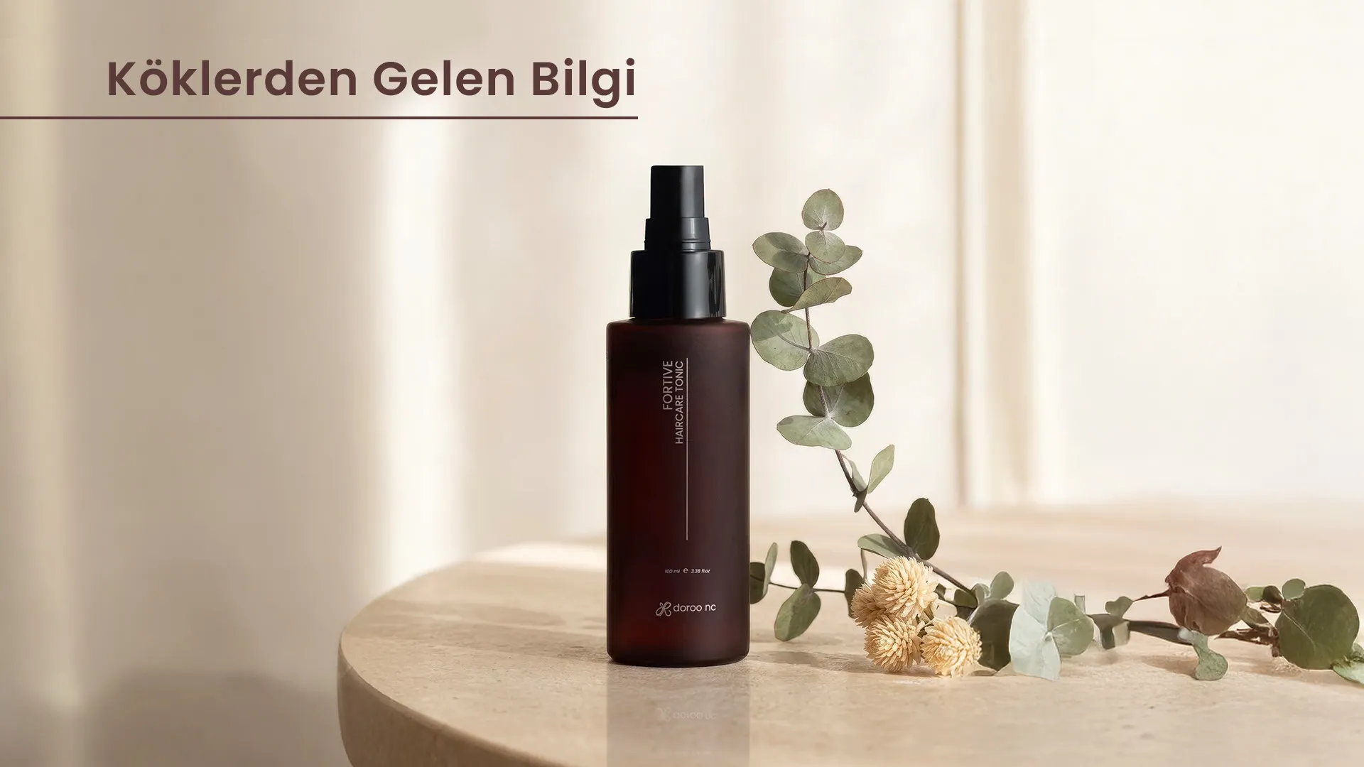 Krem tonlu bir masada okaliptüs dalları ve kuru çiçeklerin yanında Fortive saç bakım toniği; görselde “Köklerden Gelen Bilgi” yazısı